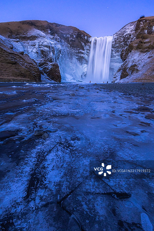 斯科加瀑布的长时间曝光夜景，月光照耀下水流平滑，星星闪烁。图片素材
