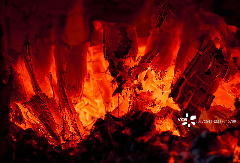 燃烧木柴的炽热发光煤炭和火焰图片素材