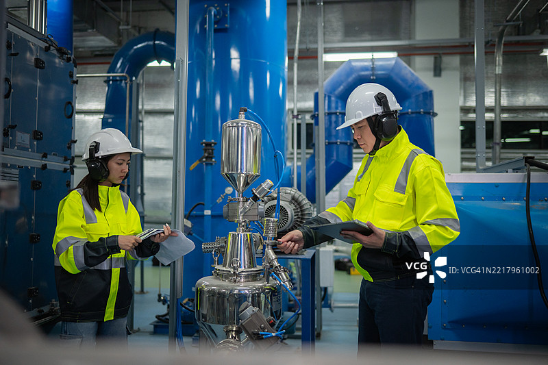 工程师或工人在工业设施的操作系统中进行检查和维护，包括暖通空调（HVAC）、化学加工或清洁能源自动化工业环境。图片素材