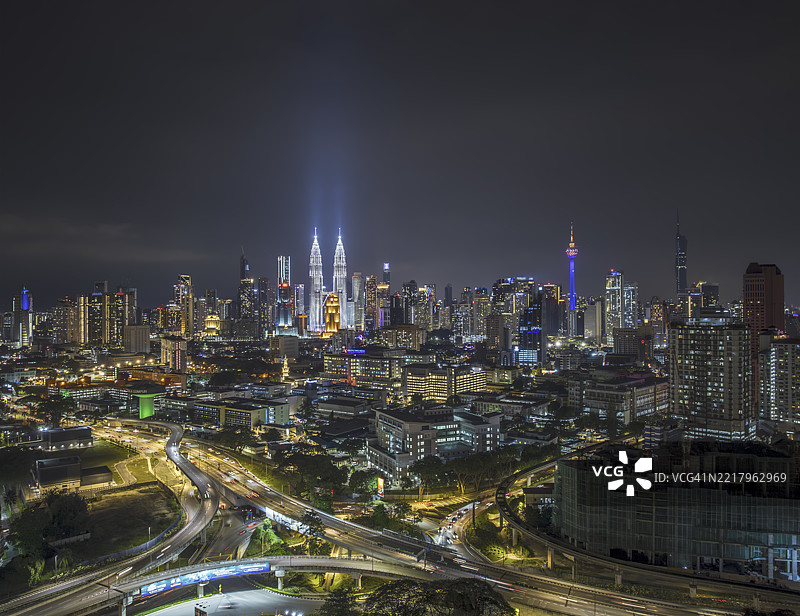动态的吉隆坡夜景：灯光璀璨的地标与流动的交通图片素材