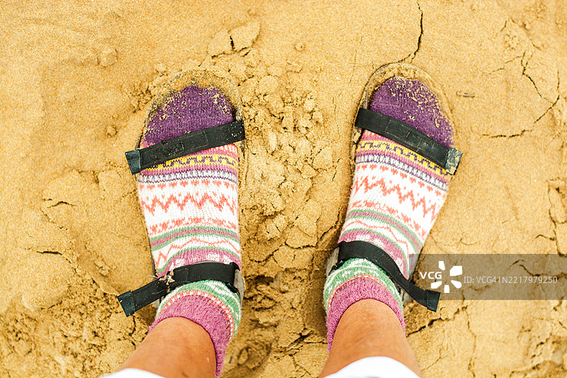 穿着彩色袜子和凉鞋的游客在沙滩上图片素材
