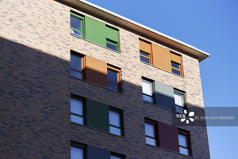现代住宅建筑的多彩外立面，配有砖墙和百叶窗图片素材