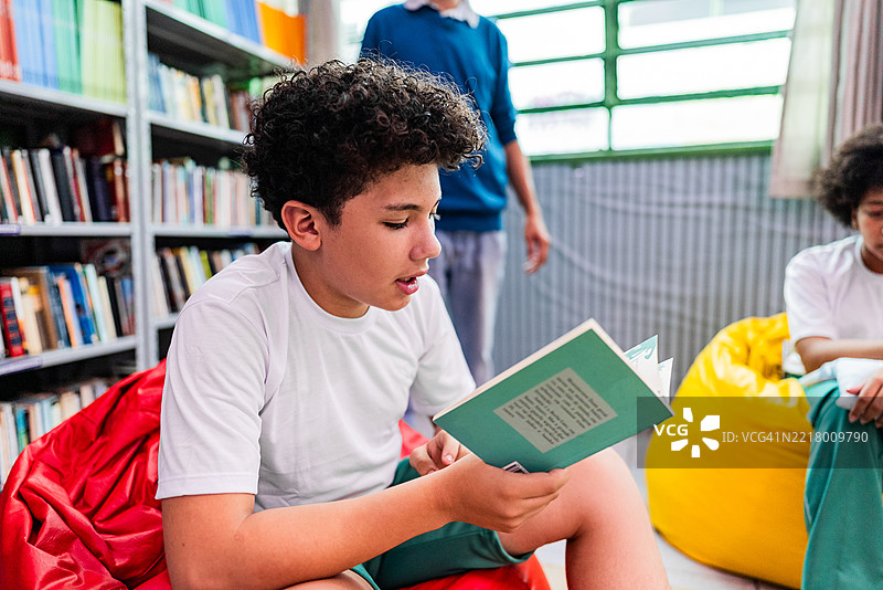 男孩在学校图书馆的集体活动中大声朗读图片素材