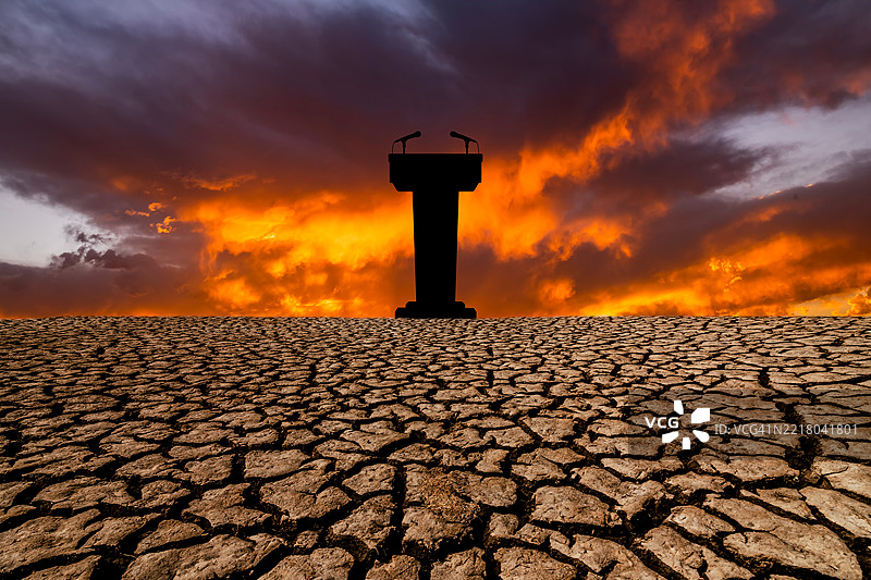 沙漠中有麦克风的讲台，背景是龟裂的地面图片素材