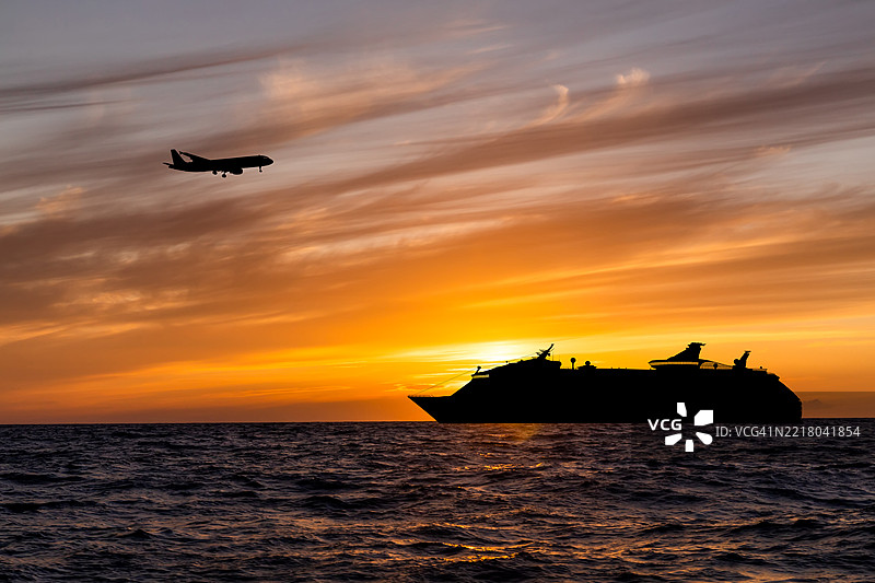 日落时分的游轮与飞行的飞机图片素材