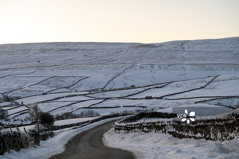 约克郡山谷中雪-covered的乡村道路。图片素材
