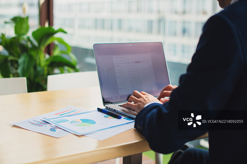商人交易员在工作并在笔记本电脑上打字图片素材