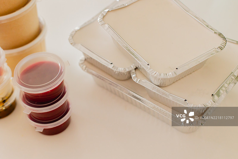 白色桌子上的各种食品容器和塑料杯图片素材