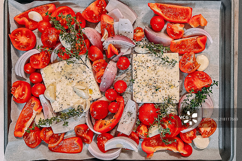 烤制番茄汤的烤盘：羊奶酪、西红柿、甜椒、洋葱、大蒜和百里香蔬菜图片素材