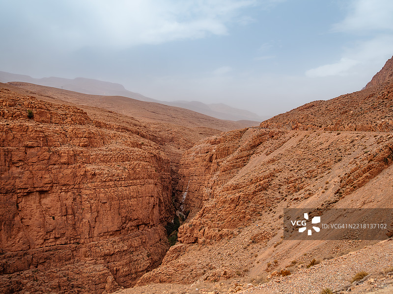 著名的达德斯河峡谷干旱景观特写，位于陡峭深邃的峡谷底部，向上延伸的空旷蜿蜒山路，布马尔内·达德斯（Boumalne-Dadès） - 丁吉尔省 - 德拉-塔菲拉勒 - 摩洛哥。图片素材