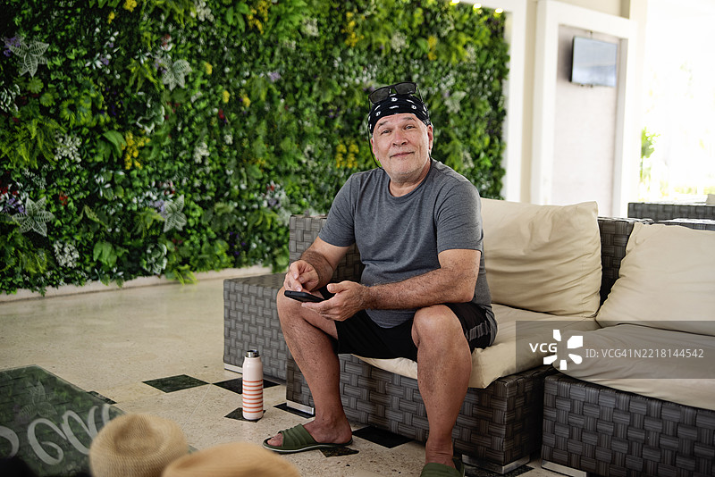 一位老年男子在等待时查看手机。图片素材