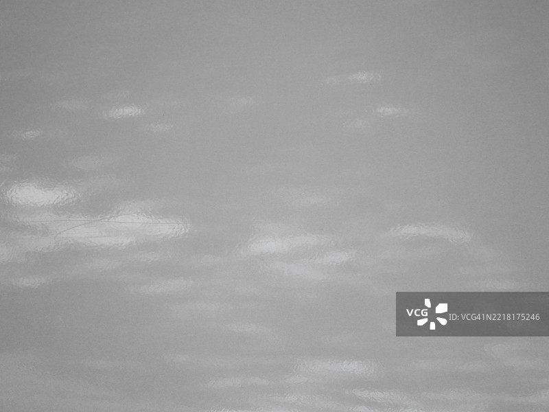 灰色汽车车身特写。光滑的涂漆金属表面有一些划痕。阳光。黑白。英国伦敦。图片素材