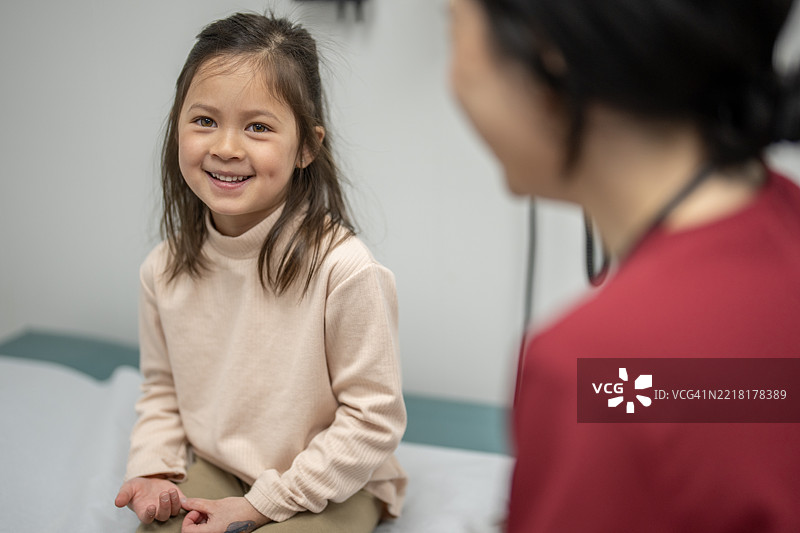 微笑的年轻女孩和关心的护士在医疗咨询中图片素材
