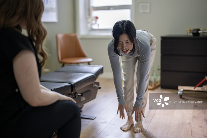 在健康诊所环境中，治疗师与患者进行物理治疗课程图片素材