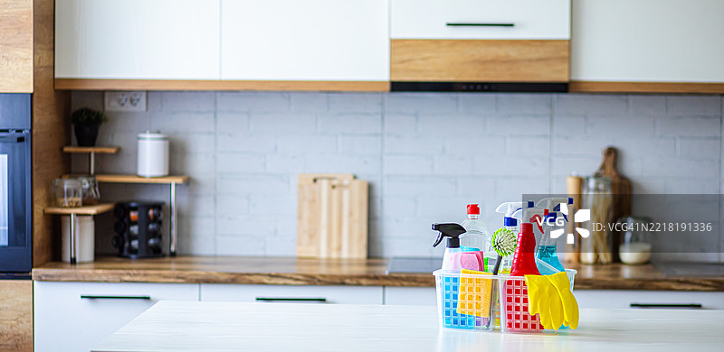 现代白色厨房中的多彩清洁用品，注重家庭卫生与消毒图片素材