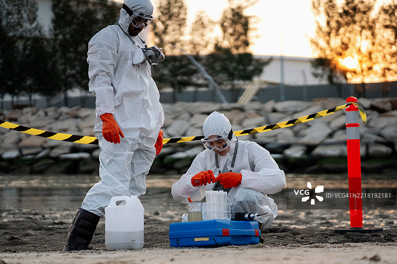 科学家或环保人士正在检查石油炼油厂周围的水和空气质量，以确定是否存在任何污染或泄漏。这反映了环保意识。图片素材