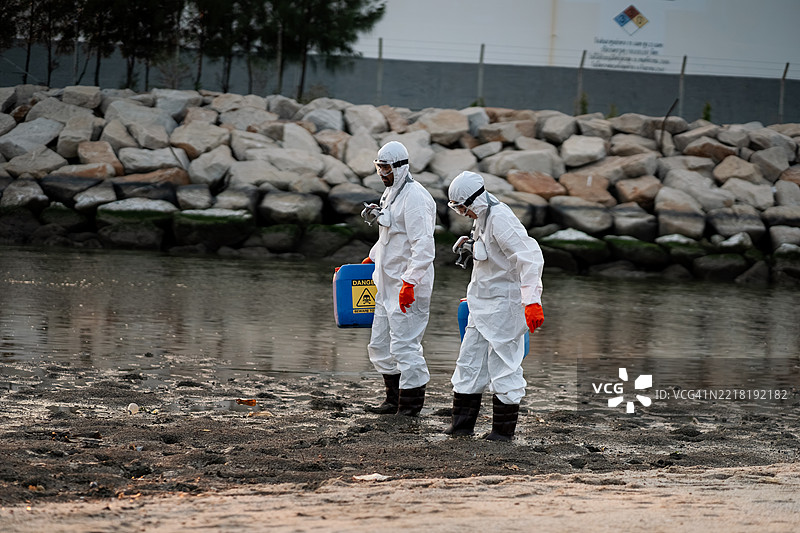 科学家或环保人士正在检查石油炼油厂周围的水和空气质量，以确定是否存在任何污染或泄漏。这反映了环保意识。图片素材