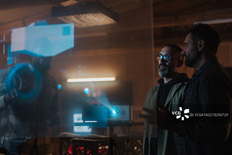 机器人研究人员正在合作进行创新项目，使用全息界面和投影仪。图片素材