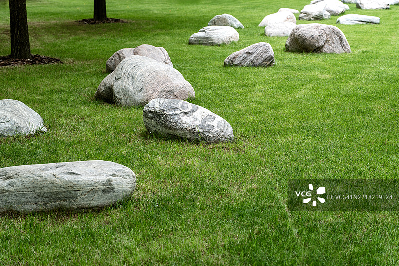 雕刻石头排列在修剪整齐的草坪上图片素材