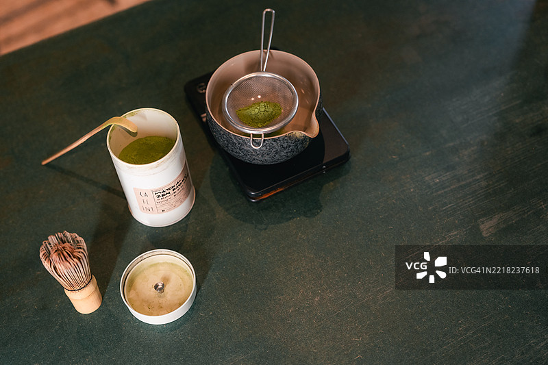特写镜头：手心思地搅拌抹茶图片素材