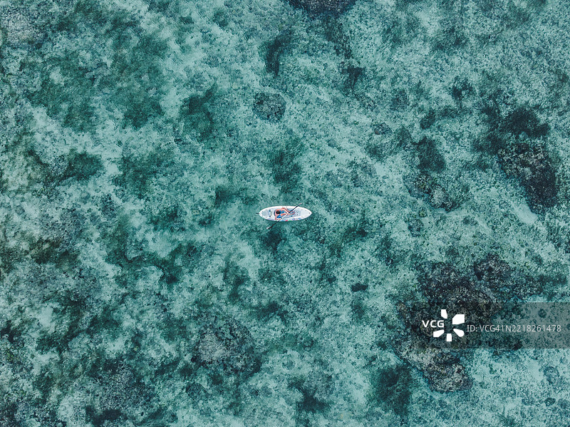 无人机拍摄的图像，俯瞰一名皮划艇运动员在印度洋上划行，地点：巴厘岛乌鲁瓦图，印度尼西亚图片素材