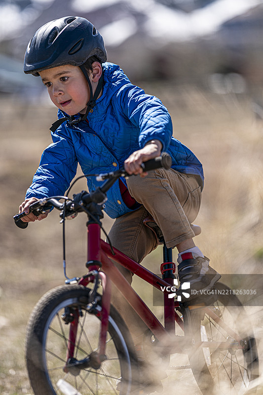 5岁男孩在崎岖地形上骑山地自行车图片素材
