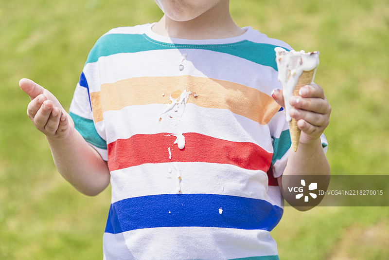 男孩吃冰淇淋弄得一团糟图片素材