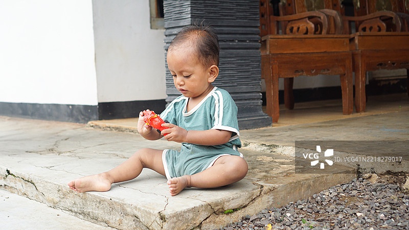 幼儿在户外玩玩具摩托车图片素材