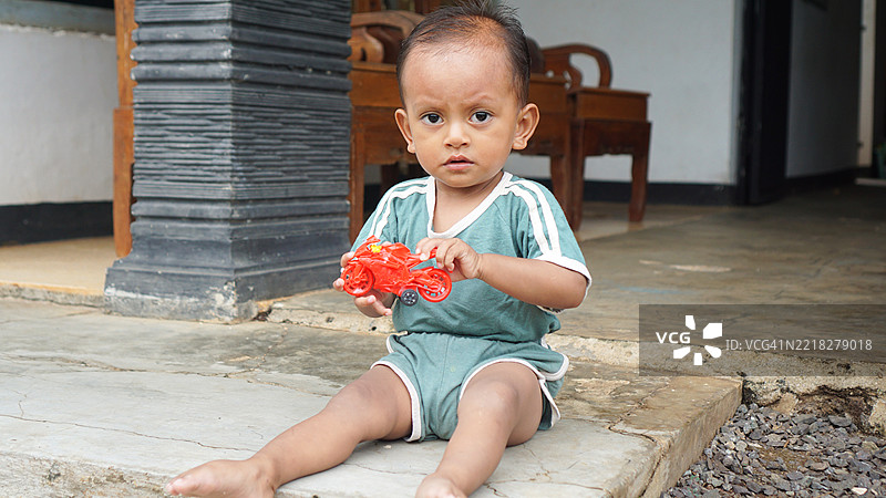 幼儿在户外玩玩具摩托车图片素材