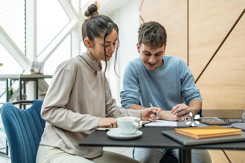 年轻学生在现代咖啡馆合作完成项目图片素材