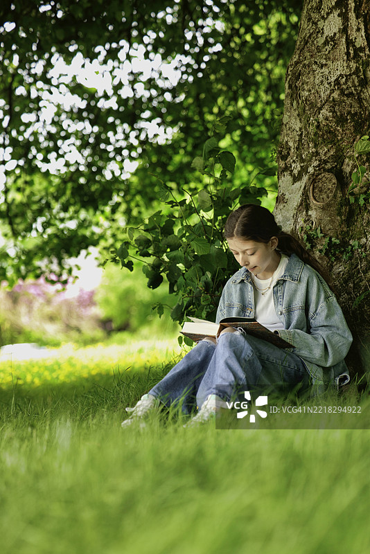 户外阅读书籍的青春期女孩图片素材