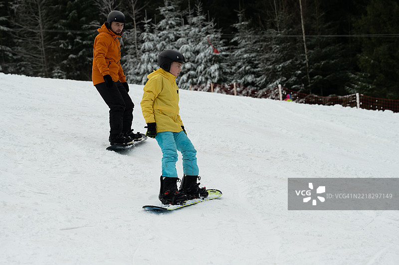 与朋友们在冬季山坡上享受刺激的滑雪冒险和快乐时光图片素材