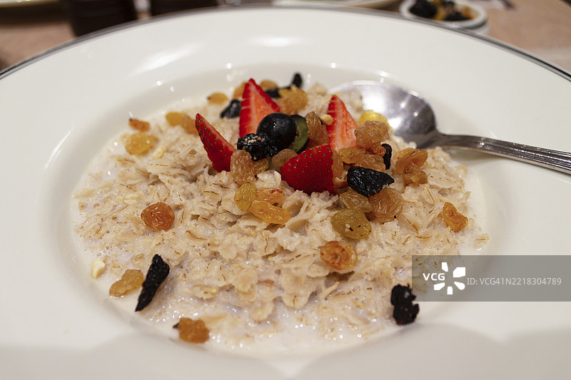 圆盘中的燕麦粥，配有浆果和葡萄干，特写镜头图片素材