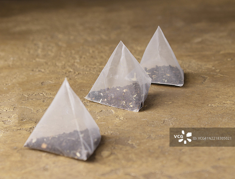 黄色背景上的三角茶包，选择性对焦图片素材