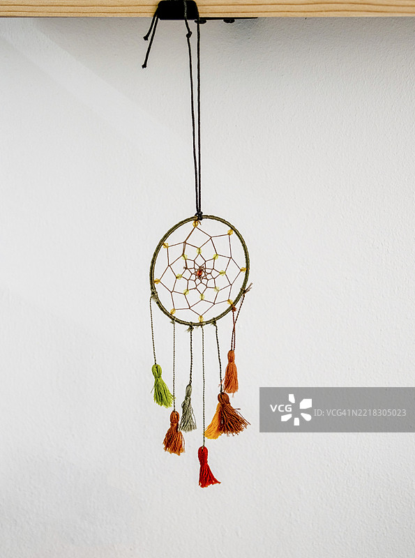 办公室墙壁背景上挂着的梦捕手，留白空间图片素材