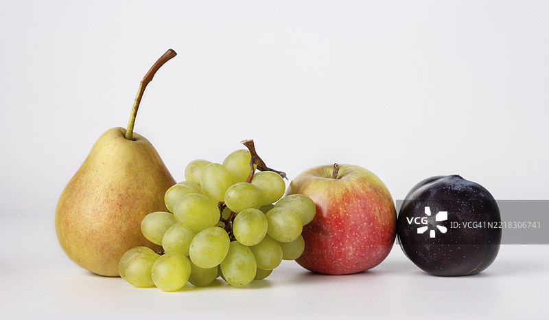 白色背景上的梨、葡萄、苹果和李子特写图片素材