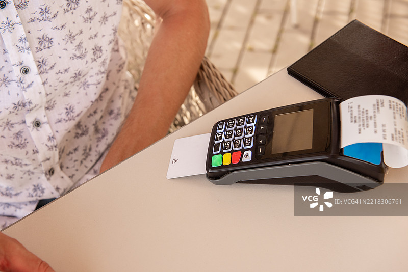 顾客在餐厅使用非接触式VISA信用卡付款图片素材