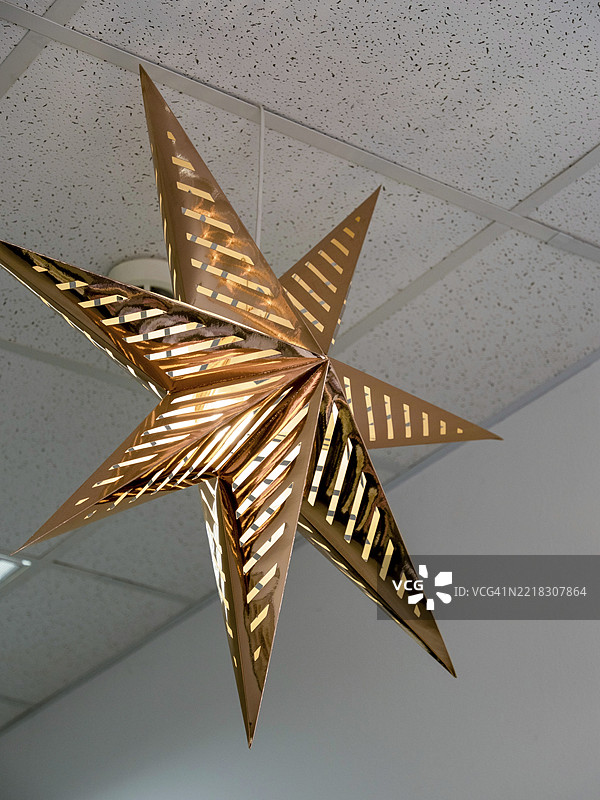 一个用金箔制成的装饰星星悬挂在办公室的天花板上图片素材