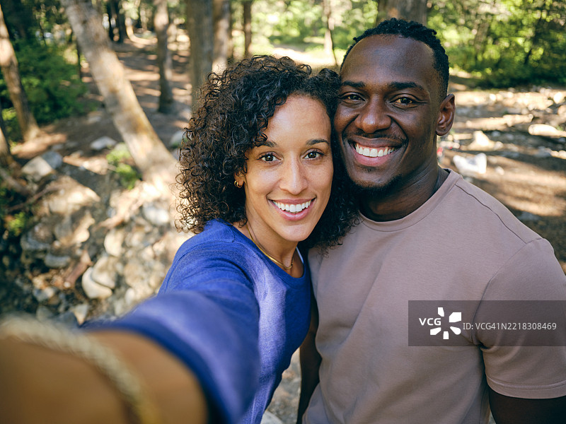 年轻情侣在徒步旅行中自拍图片素材