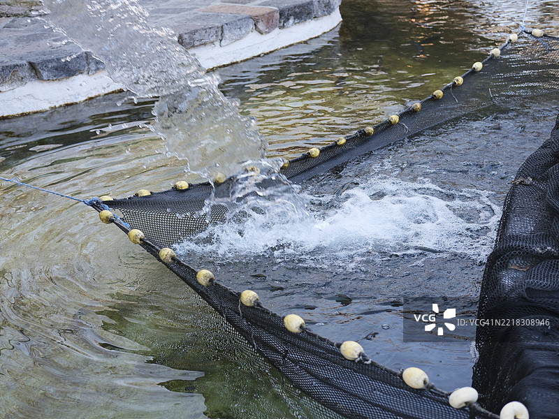 水流入鱼塘的网中图片素材