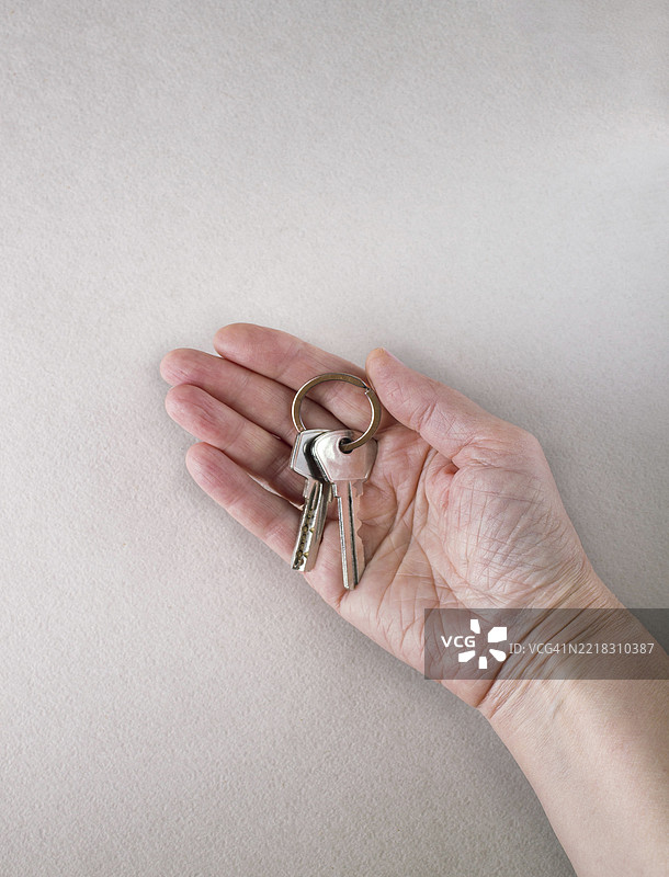 女人手中的金属钥匙，留白空间图片素材