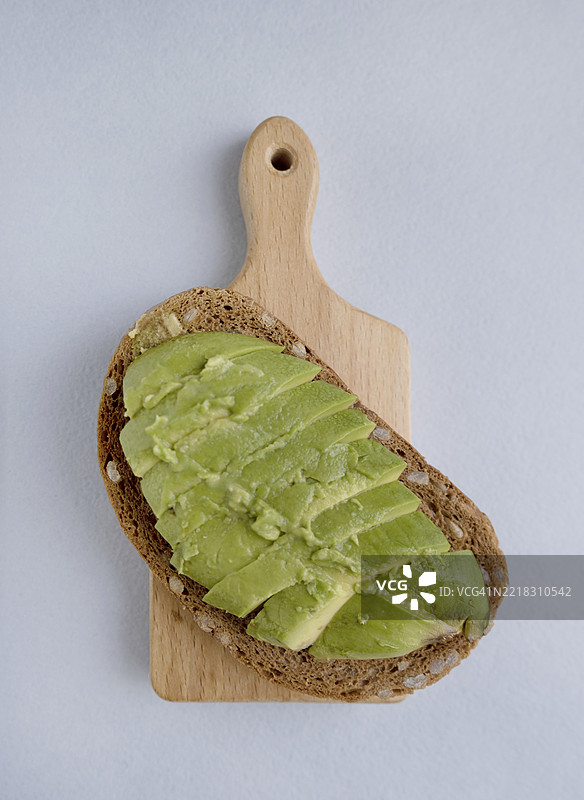 全麦面包和鳄梨三明治放在木板上，健康低卡早餐图片素材