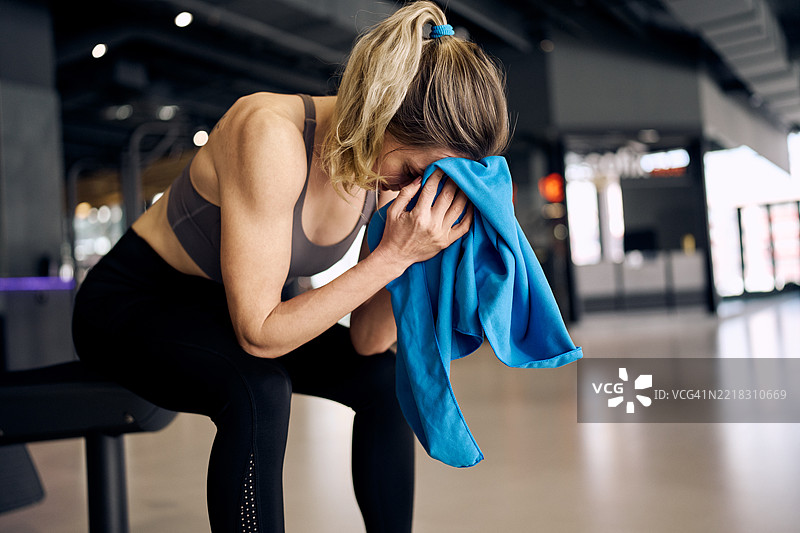 女性在锻炼后用毛巾擦脸图片素材