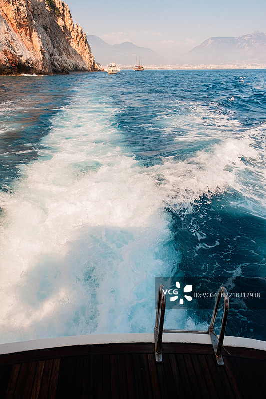 金属梯子靠近清澈蓝色水面，位于船只平台上图片素材