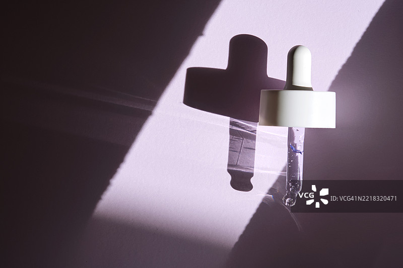 紫色背景下阳光照射下的带血清的移液管图片素材