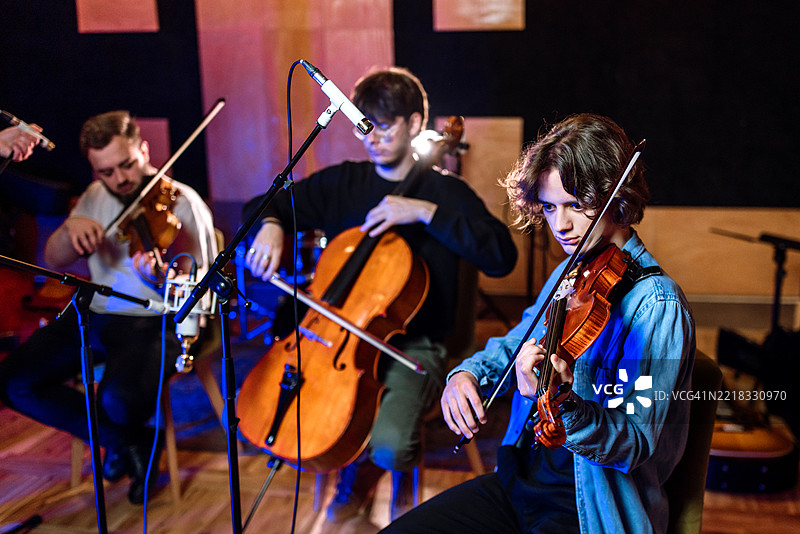 小型乐团在音乐录音室演奏。图片素材