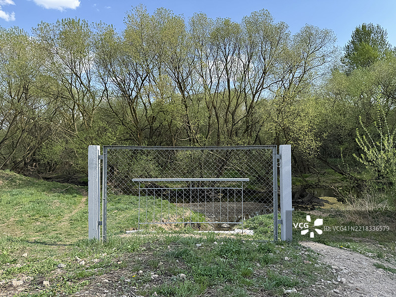 金属栅栏门阻挡着森林中的小桥图片素材