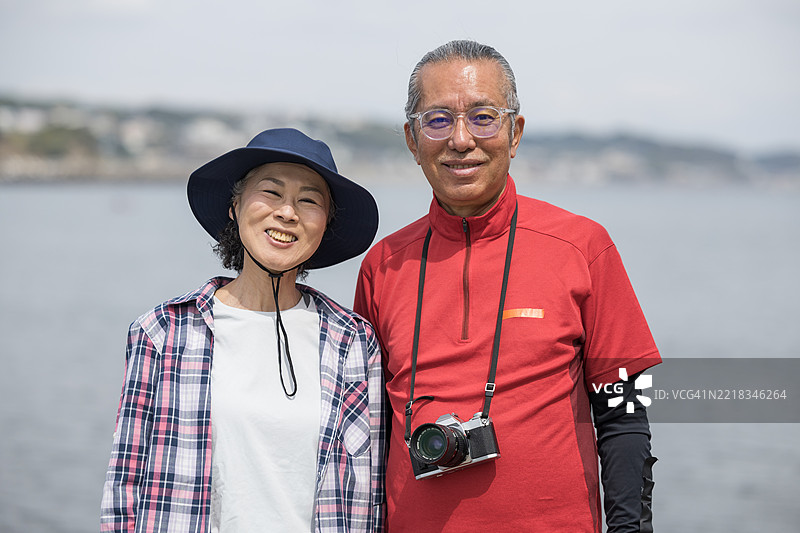 一位老年男子正在用胶卷相机拍照。图片素材