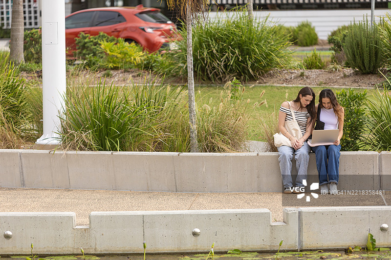年轻女性在户外使用笔记本电脑图片素材