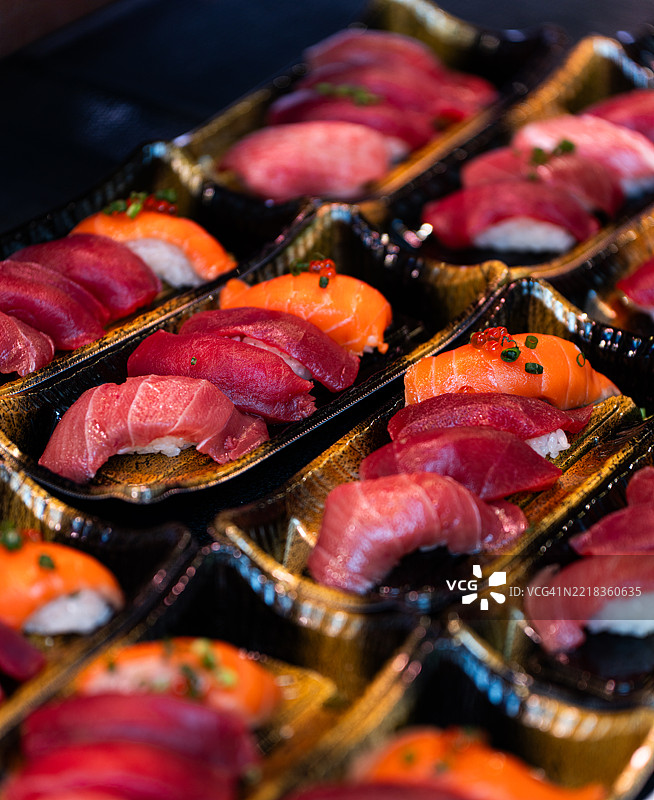 市场托盘中的多样化握寿司，配有金枪鱼和三文鱼图片素材